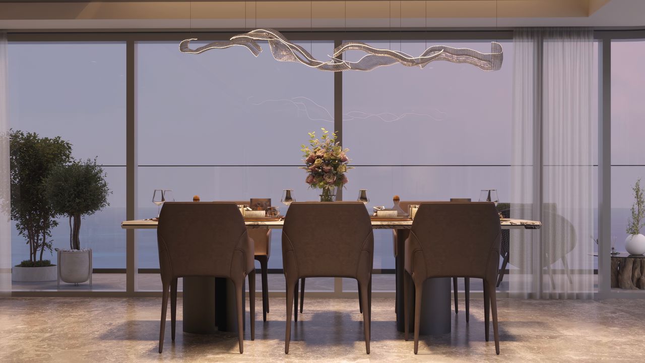 Dining table with the sea at dusk behind the glass.